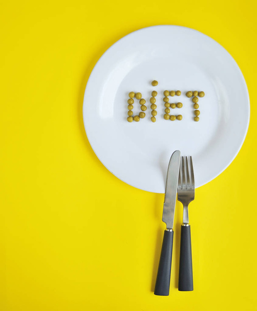 Εννοιολογική εικόνα του θέματος της δίαιτας. Πιάτο με φαγητό. Η λέξη δίαιτα που γίνεται από μπιζέλια. - Φωτογραφία, εικόνα