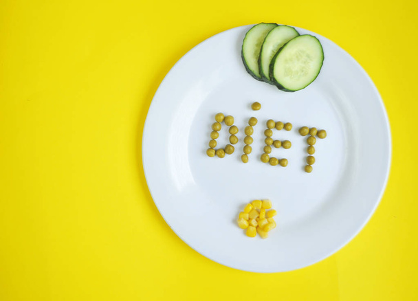 Conceptual image of diet theme. Plate with some food. The word diet made from peas. - Photo, Image