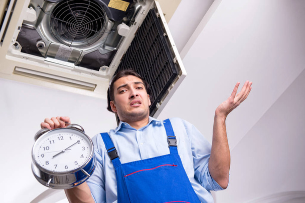 Young repairman repairing ceiling air conditioning unit  - Photo, Image