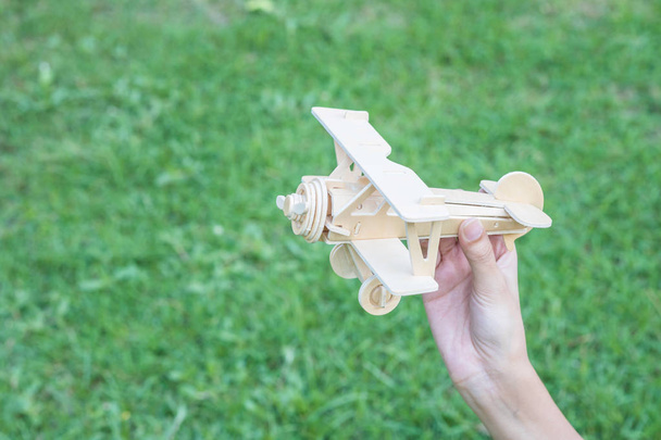 Primo piano giocattolo aereo in legno su fondo pavimento in erba
 - Foto, immagini
