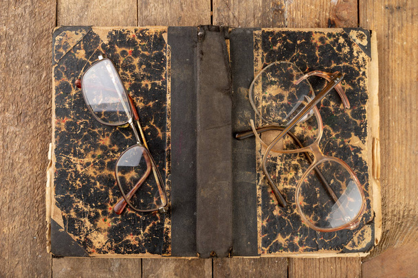 Broken frame from glasses. Old book and glasses. - Foto, afbeelding