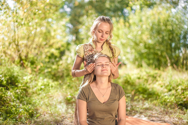 Massage expert demonstrates refreshing massaging methods on the grass. - Fotoğraf, Görsel