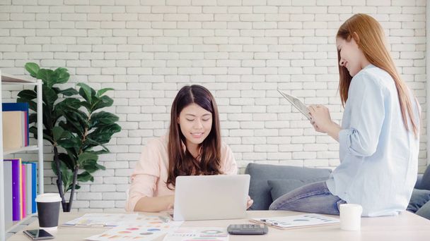 Mulheres de negócios asiáticas criativas inteligentes atraentes em roupas casuais inteligentes trabalhando no laptop enquanto estão sentadas na mesa do escritório. Mulheres trabalham no conceito de escritório
. - Foto, Imagem