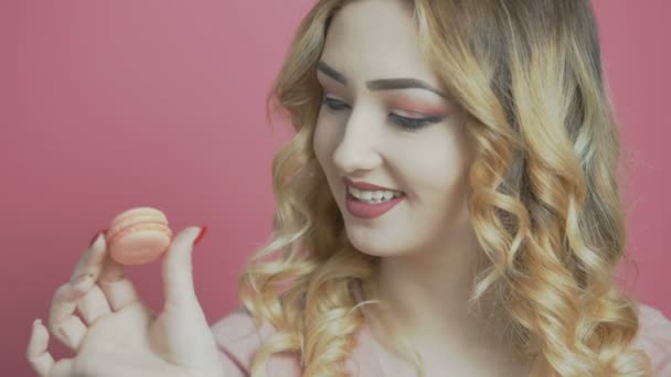 young woman with a handful of macarons, girl struggling with temptation, concept of diet, healthy eating, food advertising - Кадри, відео