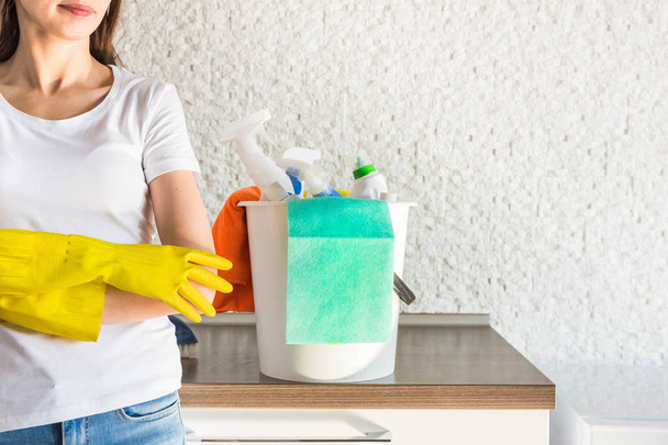 professional home cleaning. A young woman cleans the apartment. Close-up, rags, sponges and bucket, supplies staff. - Photo, image