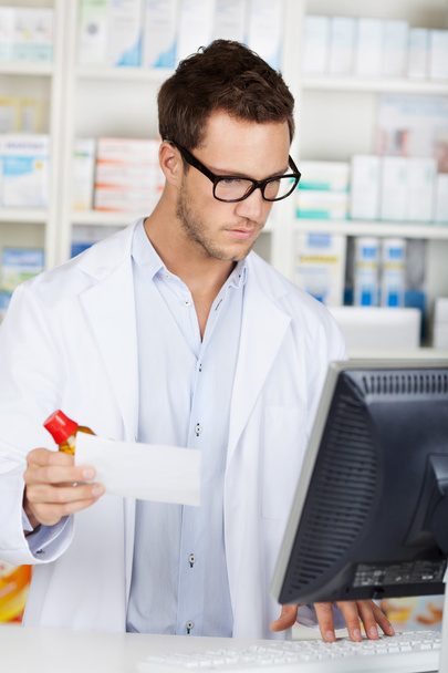 Pharmacist Checking Prescription At Drugstore - Foto, Bild