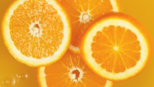 Super slow motion of orange slices falling into juice. Filmed on high speed cinema camera, 1000 fps. - Imágenes, Vídeo