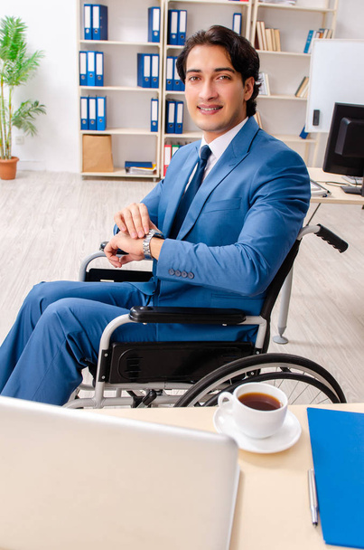 männlicher Mitarbeiter im Rollstuhl im Büro  - Foto, Bild