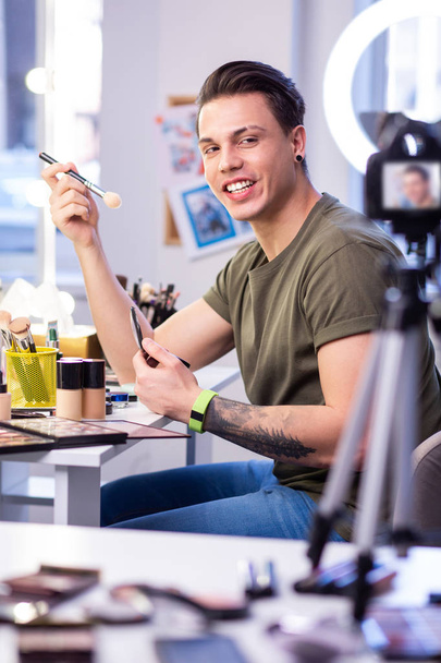 Active skilled man sitting at the beauty table in studio - Foto, Imagen