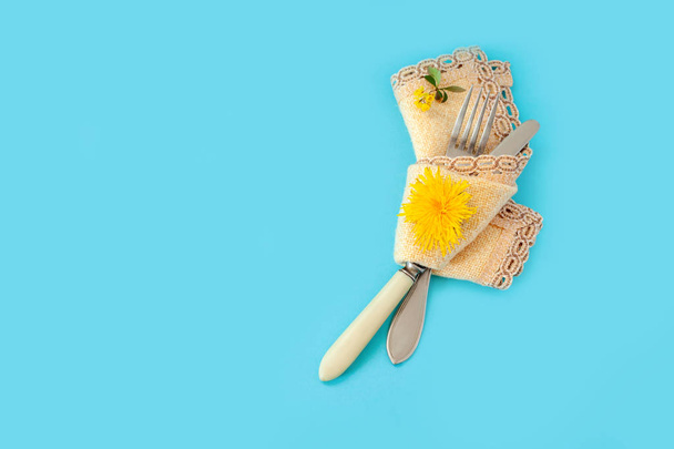 yellow background plug fork knife flower blue dandelion green yellow bouquet bunch napkin towel - Photo, Image