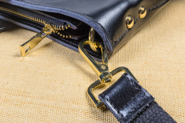 Fragmento de bolso negro con algunos accesorios de bolsa de metal amarillo
 - Foto, imagen