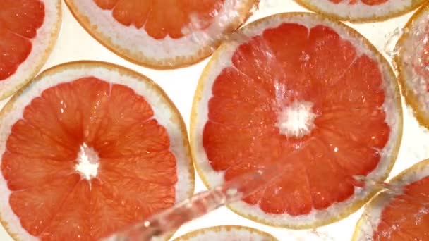 Super slow motion of grapefruit slices with water splash. Filmed on high speed cinema camera, 1000 fps. - Footage, Video