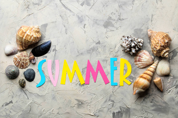 Inscription summer from paper of multi-colored letters and seashells on a light background. Summer. relaxation. vacation. top view - Foto, imagen