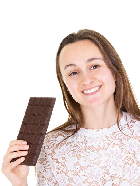 Retrato de una joven feliz sosteniendo una barra de chocolate
 - Foto, imagen