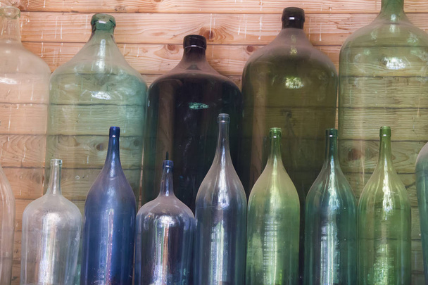Стеклянные разноцветные винные бутылки пыльные
 - Фото, изображение