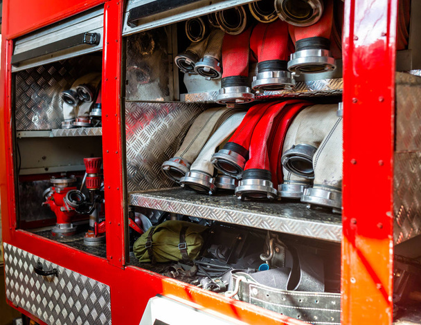 Sırahalinde düzenlenmiş yangın hortumları, itfaiye aracının torpido gözünde. - Fotoğraf, Görsel