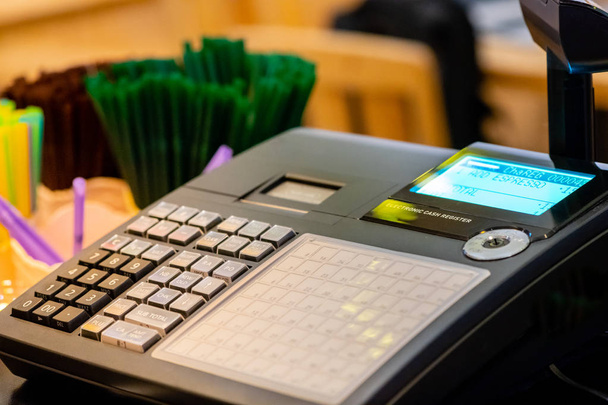 cash register installed on counter for accepting order from customer.sales man entering amount on electronic cash register in coffee shop and retail store.restaurant cashier typing on cash register. - Photo, Image