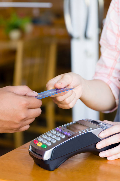 Nahaufnahme Kunden Hand halten und Bezahlung für Bestellung per Kreditkarte ca. - Foto, Bild