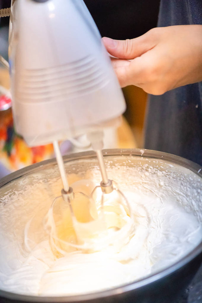 Krem şanti pişirme süreci. Kadın taze kremayı karıştırıyor. - Fotoğraf, Görsel