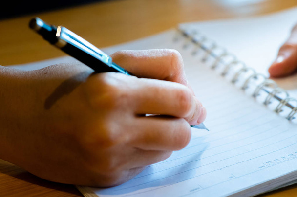 mano femenina con escritura a lápiz en el cuaderno en la cafetería shop.woman
 - Foto, imagen