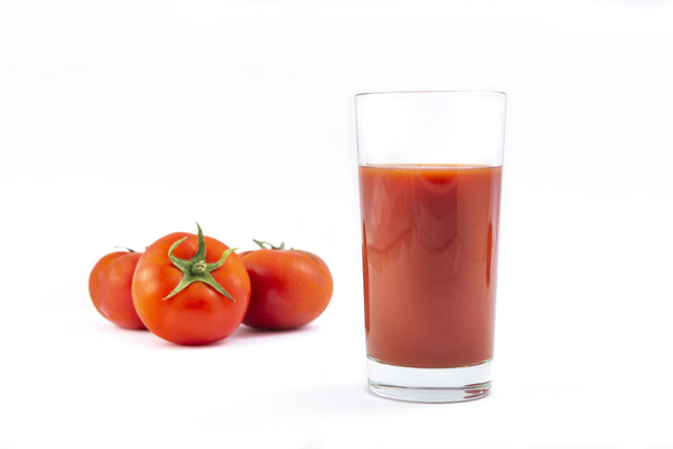 Glass with fresh tomato juice  and  tomatoes on a white background - Фото, изображение