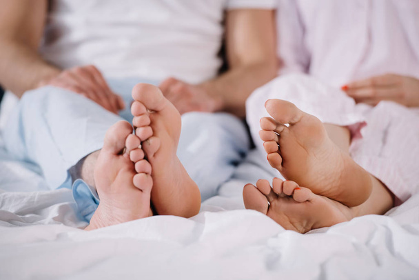 cropped view of barefoot of husband and wife in bedroom  - Fotoğraf, Görsel