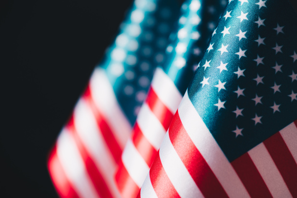 selective focus of usa national flags isolated on black, memorial day concept - 写真・画像