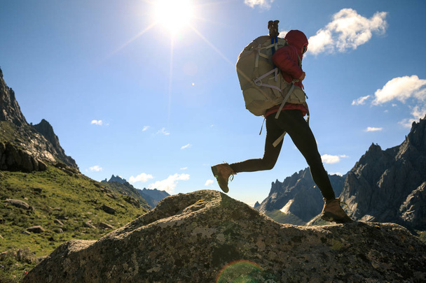 Woman hiker with backpack hiking on high altitude mountain top - Foto, imagen