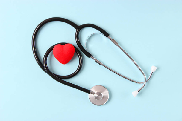 Стетоскоп и сердце на деревянном цветном фоне. Медицина, здравоохранение - Фото, изображение
