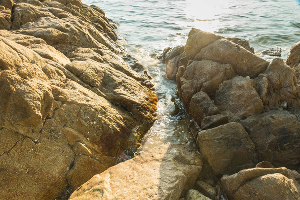 Vlny na kamenných plážových vodách jsou na okraji abstraktního mořského pozadí. Thailan - Fotografie, Obrázek