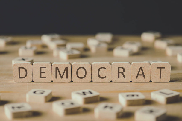 szelekciós középpontjában Demokrata felirat a kockákon körülvett blokkok betűkkel a fa felületén izolált fekete - Fotó, kép