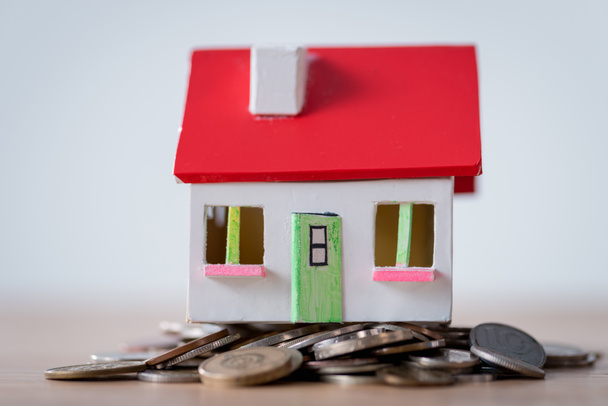 house model with red roof and white walls on metal coins isolated on grey - 写真・画像
