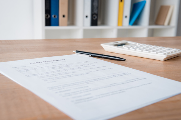 contrat de prêt, stylo et calculatrice sur table en bois au bureau
 - Photo, image