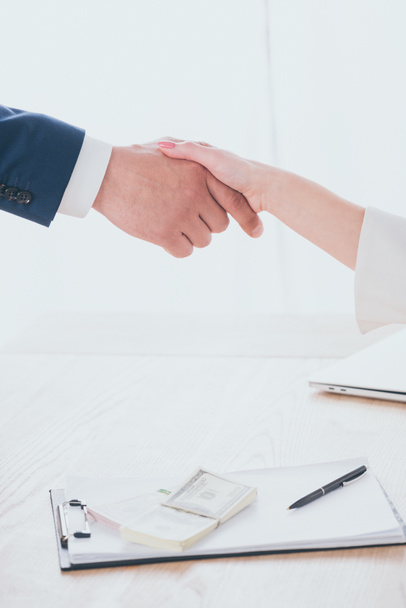 partial view of businessman and woman shaking hands in office - Foto, Imagem