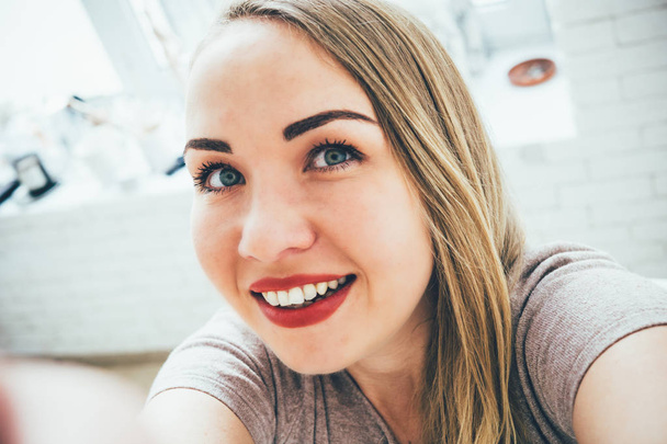 Souriant jeune femme blonde européenne faisant du selfie dans son studio
 - Photo, image