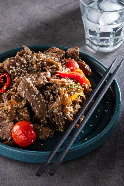 Soba noodles with beef, mushrooms, cherry tomato and sweet peppers. Asian cuisine. - Valokuva, kuva