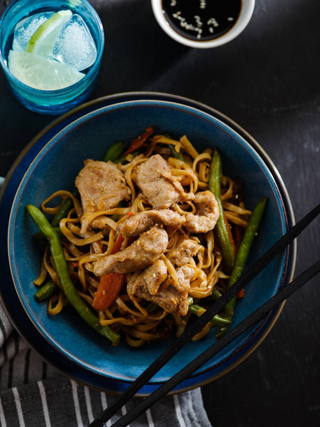Asian noodles with pork in teriyaki sauce, with green beans, carrots and shiitake mushrooms. Top view. - 写真・画像