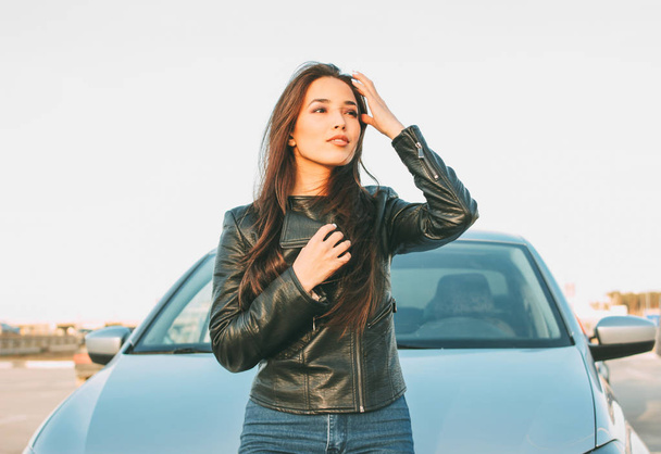 Гаппі красива чарівна брюнетка довге волосся молода азіатка в чорній шкіряній куртці біля її машини
 - Фото, зображення