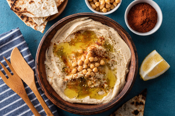 Classic Hummus with chickpeas, paprika, olive oil and oriental spices. Mediterranean popular snack of chickpeas and tahini pasta. - Photo, Image