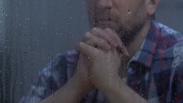 Middle-aged male praying god behind rainy window, hoping for better, belief - Filmati, video
