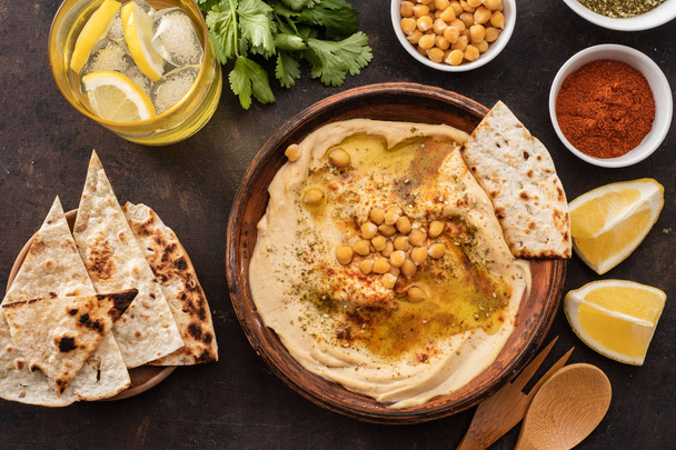 Classic Hummus with chickpeas, paprika, olive oil and oriental spices. Mediterranean popular snack of chickpeas and tahini pasta. Vew from above. Flat lay. - Фото, изображение