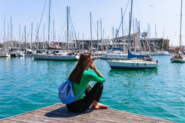 Tourist woman in the port of Barcelona, Catalonia, Spain. Scenic seascape of marina and sailboats yachts. Public promenade and famous tourist destination near La Ramblaa street - Φωτογραφία, εικόνα