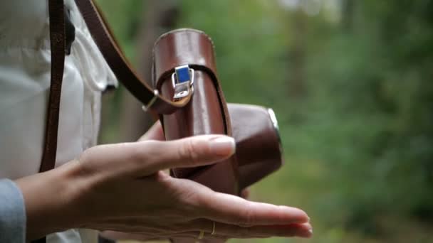 schöne weibliche Hände spielen mit einer braunen Kamera in einem grünen Wald in slo-mo - Filmmaterial, Video
