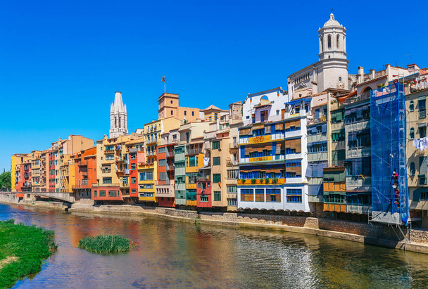 Värikäs punainen, oranssi ja keltainen taloa ja silta läpi joen Onyar Girona, Katalonia, Espanja. Scenic muinainen kaupunki. Kuuluisa matkailukohde täydellinen paikka loma ja loma
 - Valokuva, kuva