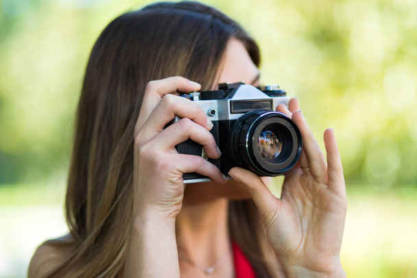 ritratto di una donna felice che scatta foto con una fotocamera DSLR
 - Foto, immagini