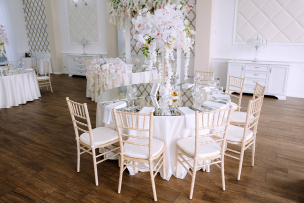 gyönyörű virágos dekorációk, asztalok székekkel esküvői fogadás   - Fotó, kép