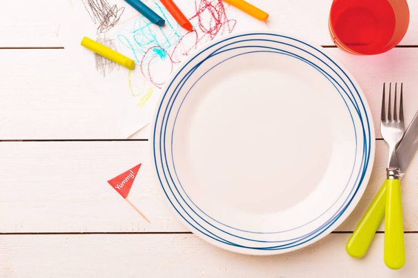 Table setting for kids - empty plate with decorations around - Zdjęcie, obraz