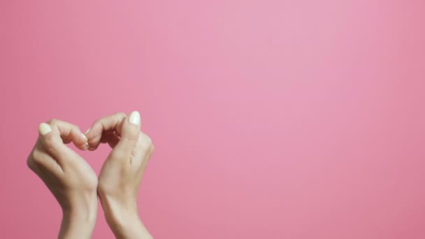 женские руки в форме сердца, креативное признание в любви, живая открытка, сердцебиение на фоне студии розового цвета
 - Кадры, видео