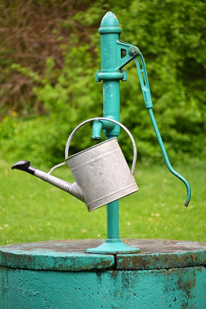 Klassieke handpomp voor water-goed met waterkoker voor het drenken van de tuin. - Foto, afbeelding