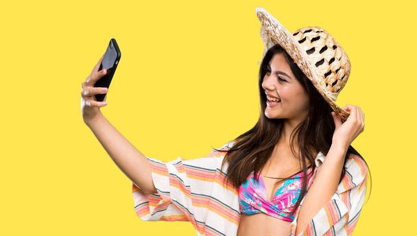 Девочка-подросток на летних каникулах делает селфи на изолированном желтом фоне
 - Фото, изображение